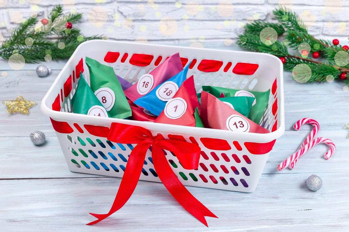 Colorful DIY advent calendar boxes filled with little gifts in a festive bucket