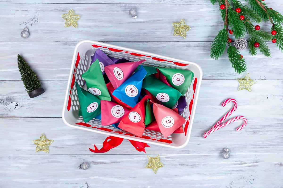 Colorful festive advent calendar boxes arranged in a bucket, top-down view